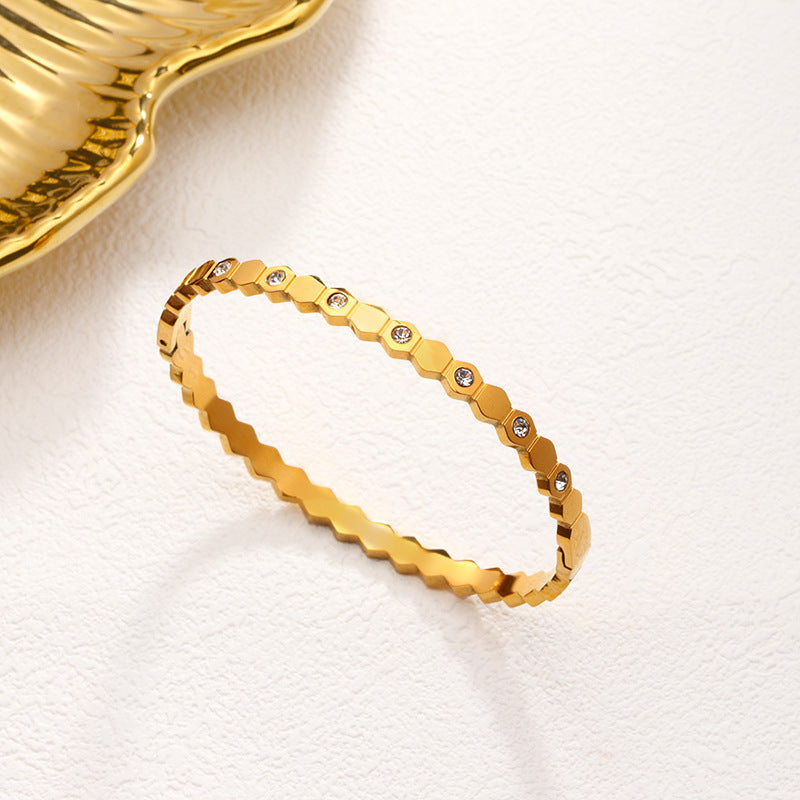 Gold bracelet with diamond accents on a white background