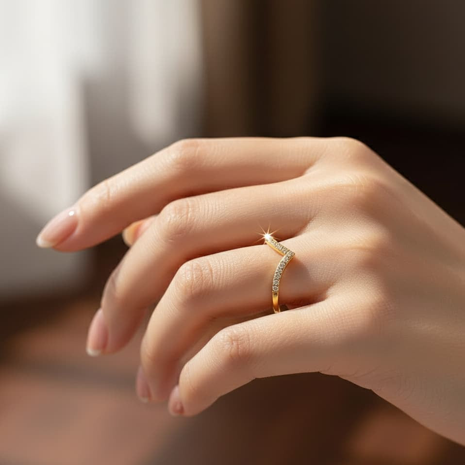 Hand wearing a gold ring with small diamonds on a blurred background