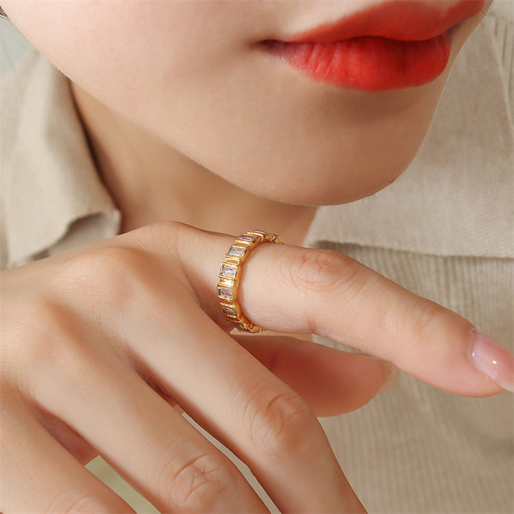 Close-up of a hand wearing a gold ring with a blurred background