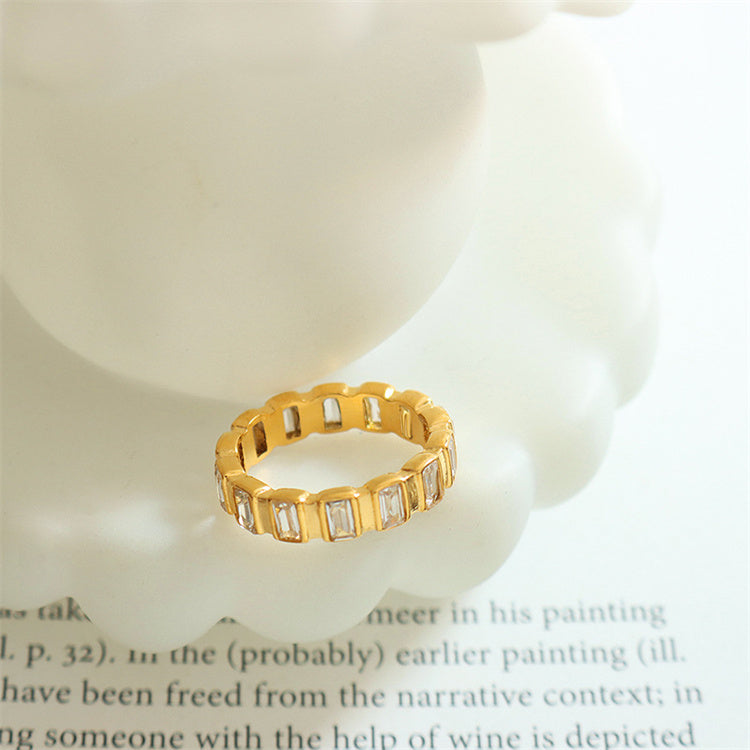 Gold ring with baguette diamonds on a white surface