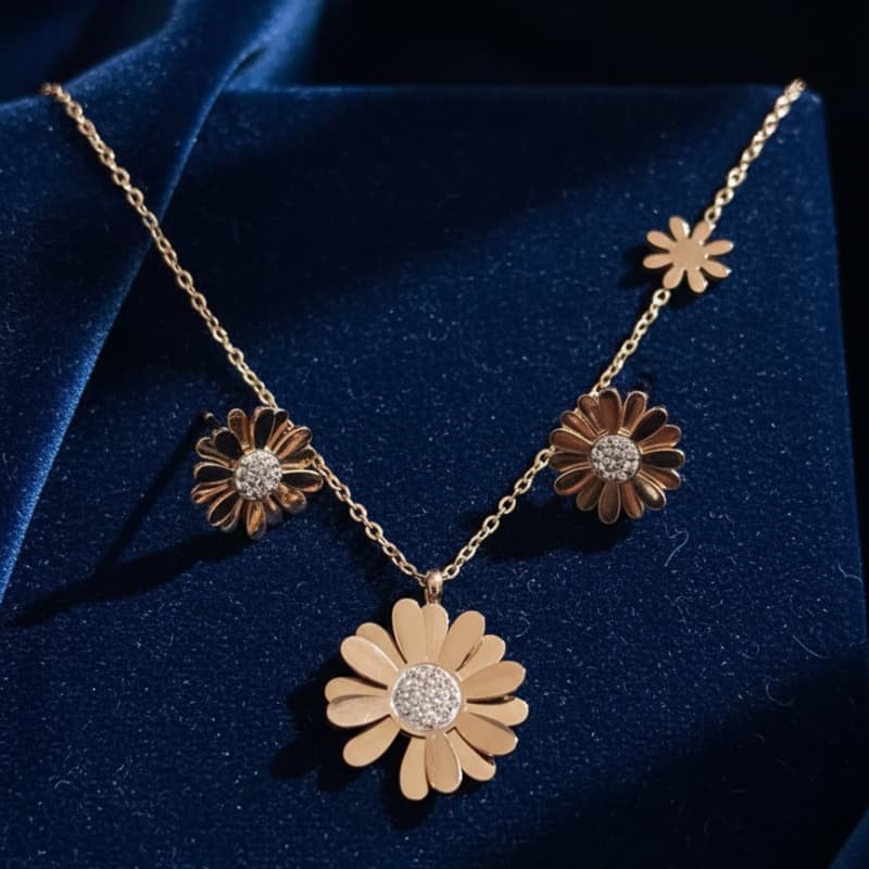 Gold necklace with flower pendants on a blue fabric background