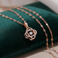 Rose gold necklace with a diamond pendant on a green cushion