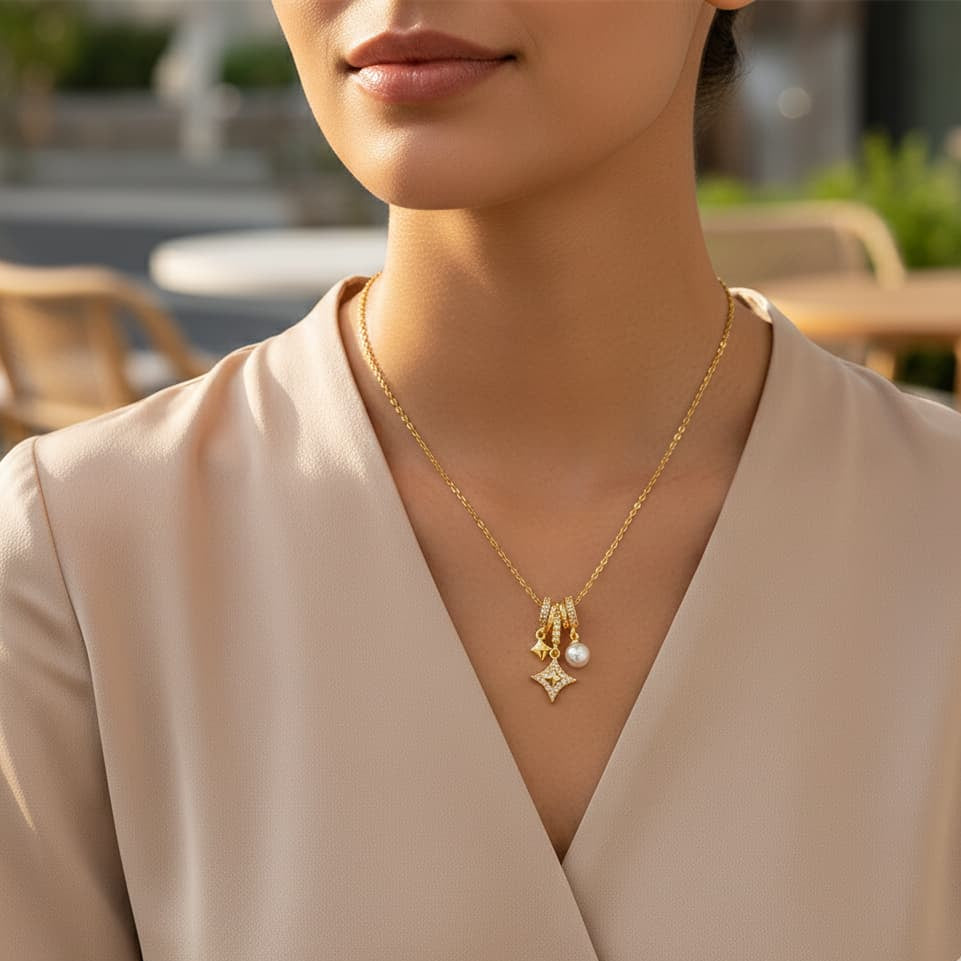 Woman wearing a gold necklace with a pearl pendant in an outdoor setting