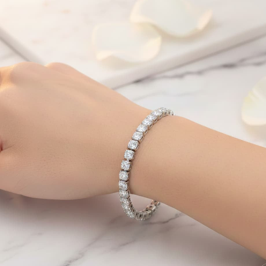 Silver bracelet on a wrist against a marble background