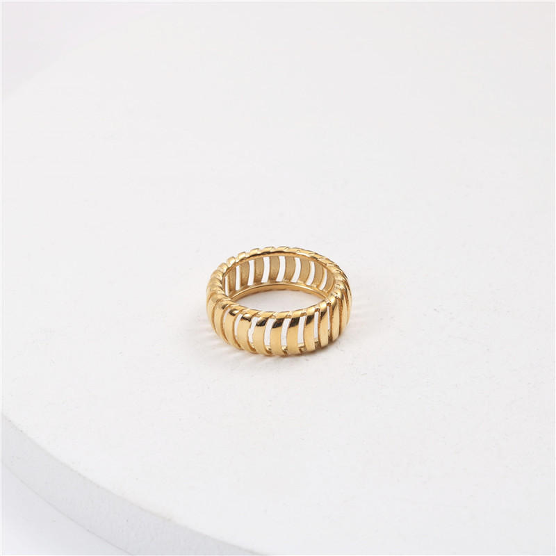 Gold ring with a ribbed design on a light gray background